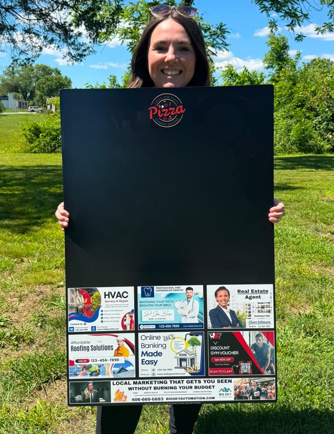 A woman holding a community advertising board with space for a restaurant message above local business ads